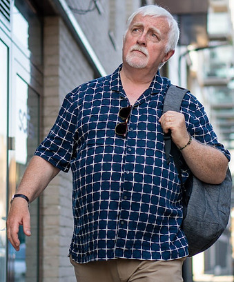 older man with backpack walking
